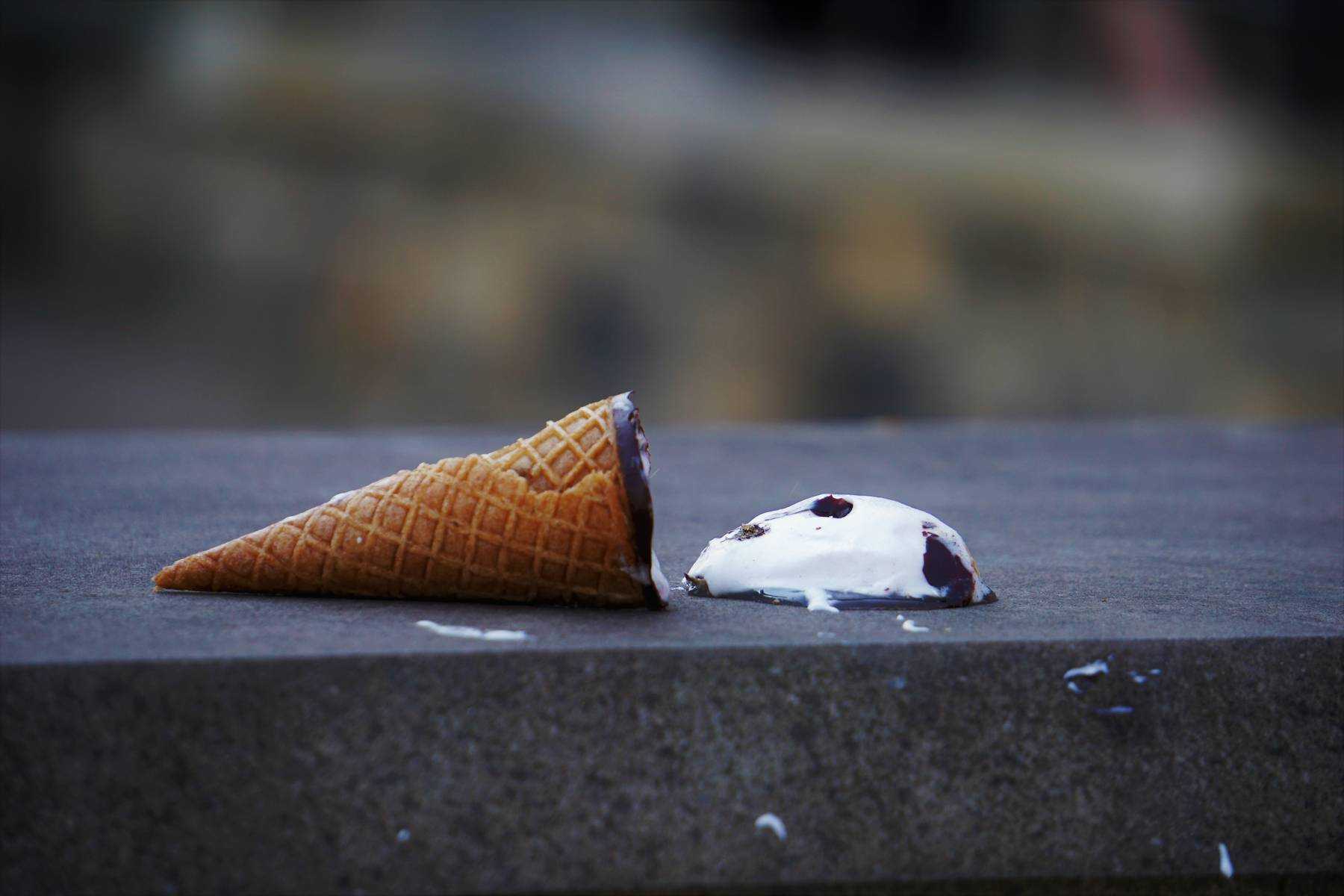An ice cream cone splattered on the ground